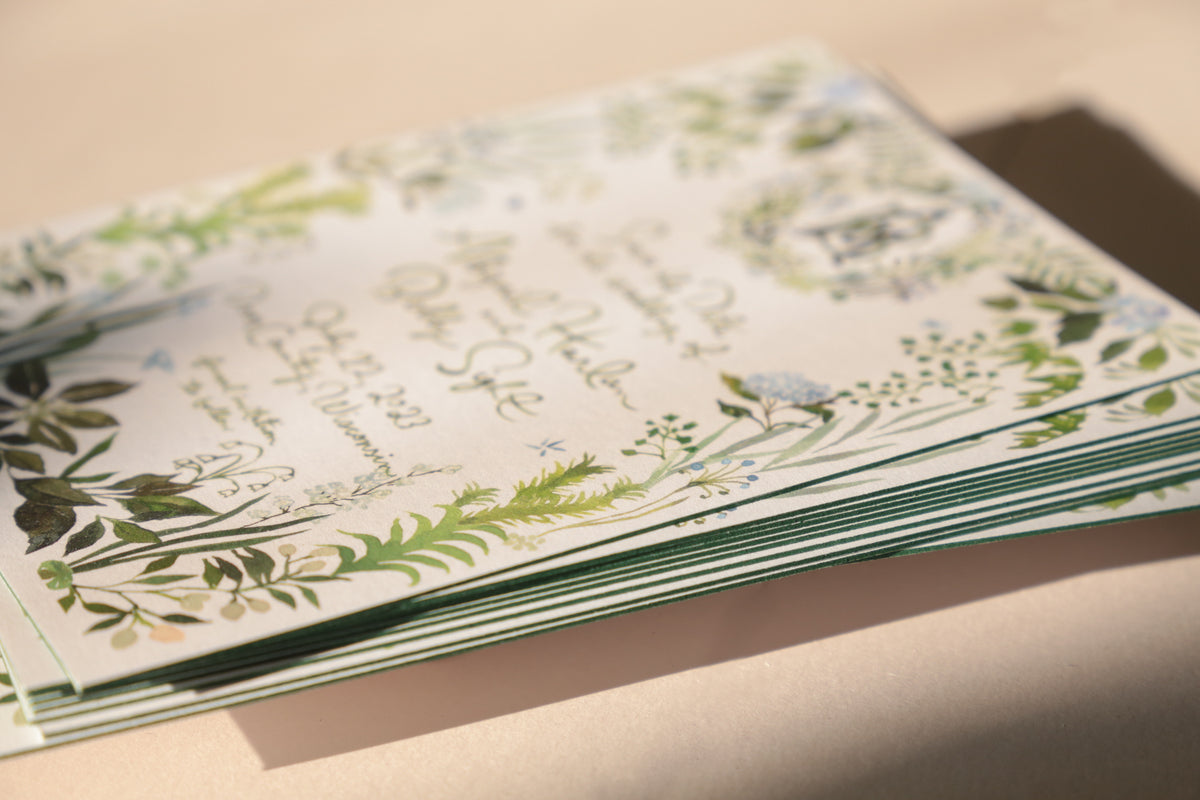 Stack of greeting cards with floral designs on a light surface