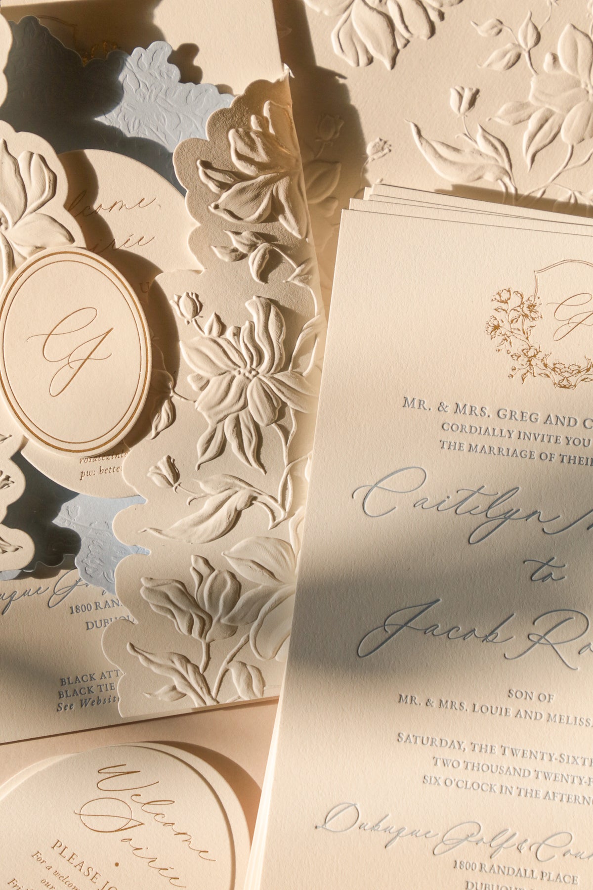 Detailed wedding invitation with floral embossing and elegant text.