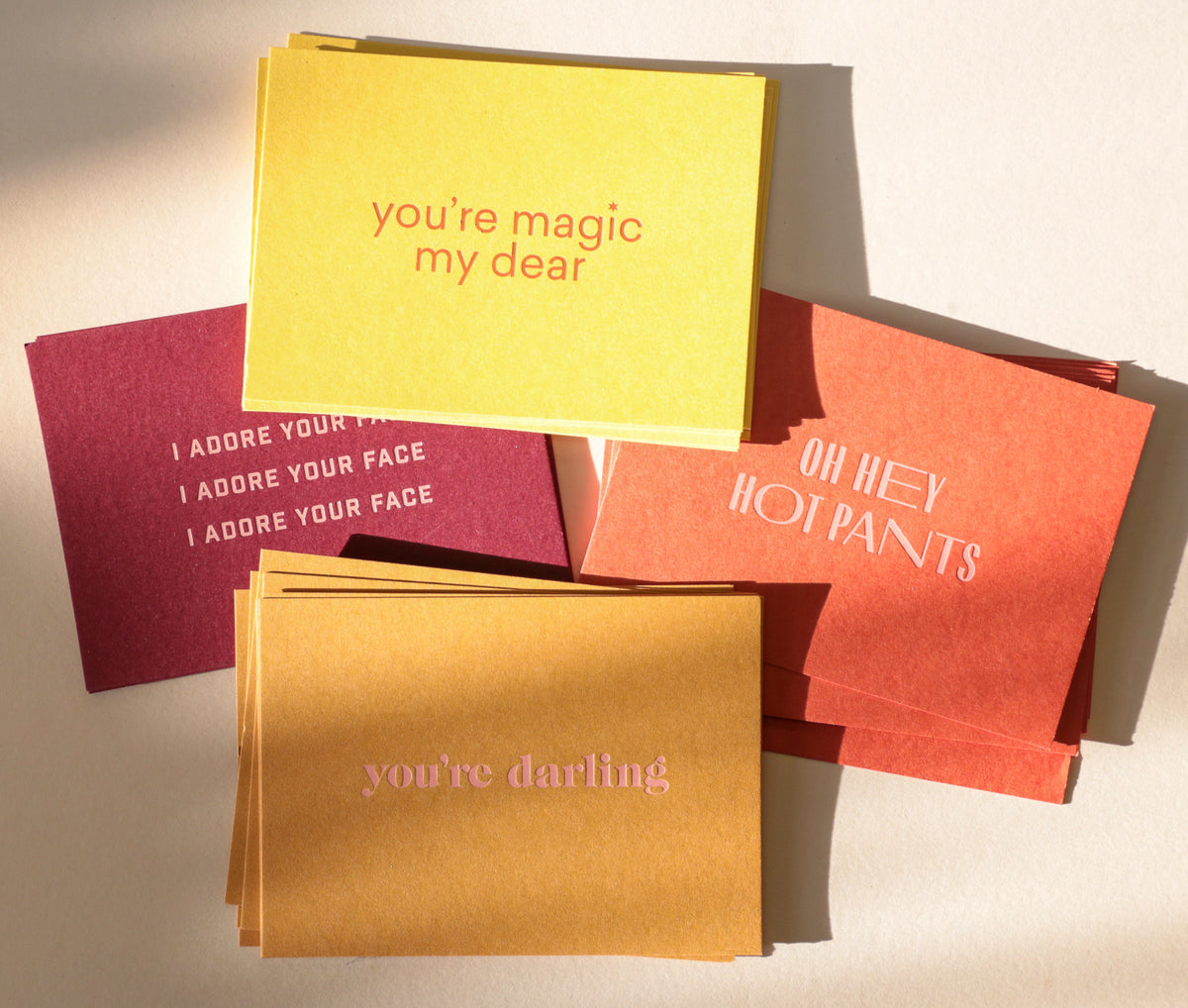 Stack of colorful greeting cards with text on a neutral background