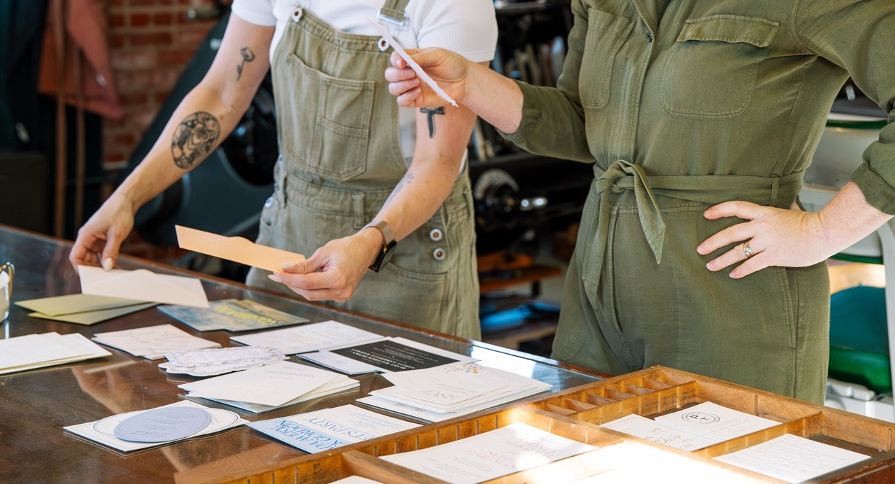 two women collaborating on wedding invitation design
Photo by Alyssa Broadus